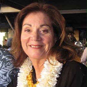 Color photo of Lillian Watson in later years, smiling and wearing a white flower lei